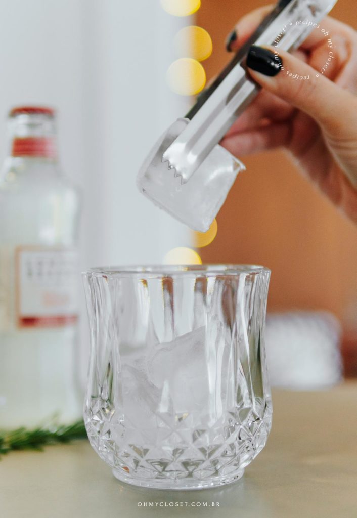 Mais do preparo do drinque, colocando o gelo no copo.