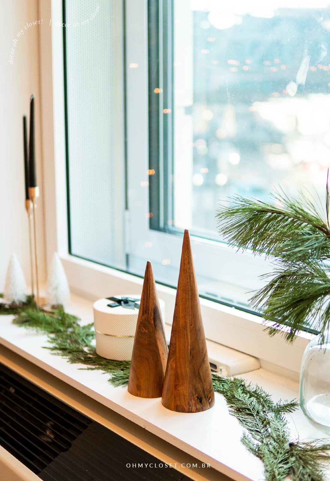 Outro ângulo da decoração de natal com árvores de madeira cônicas e folhagens de pinheiro.