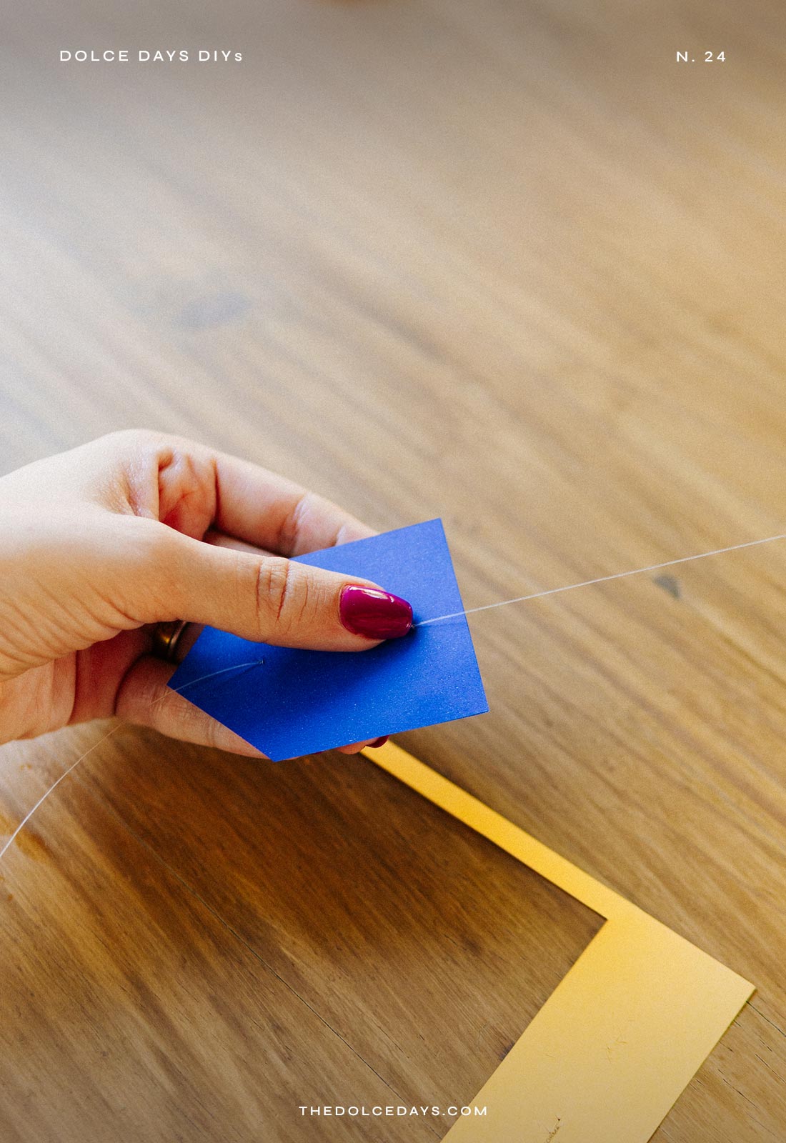 Passando o fio de nylon pelo furo de cima da bandeirinha