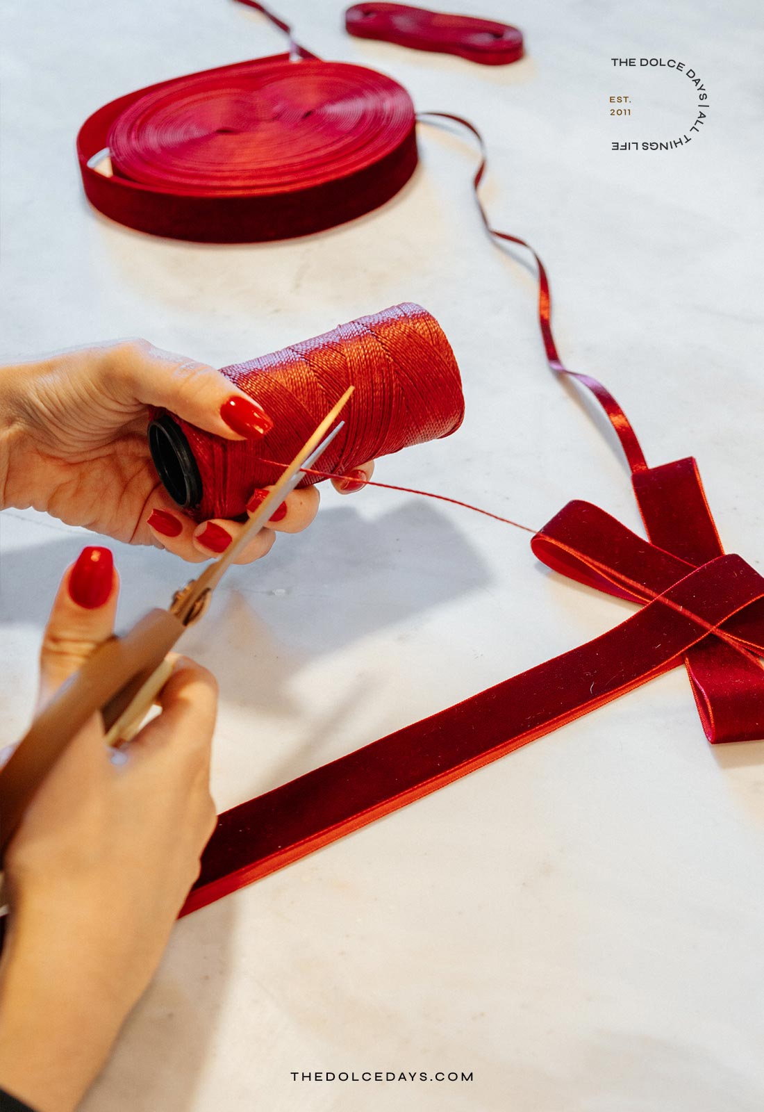 Cortando um pedaço de fio encerado para amarrar o laço no festão