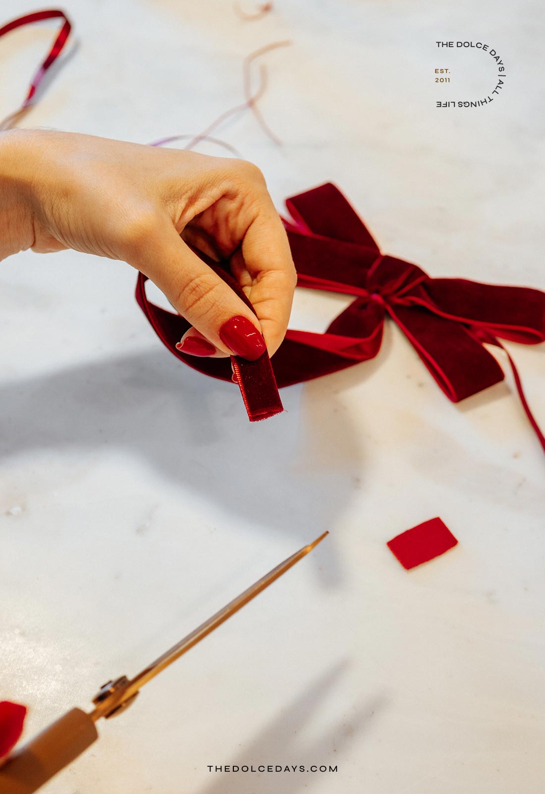 Dobrando as pontas do laço pra finalizar o DIY do festão