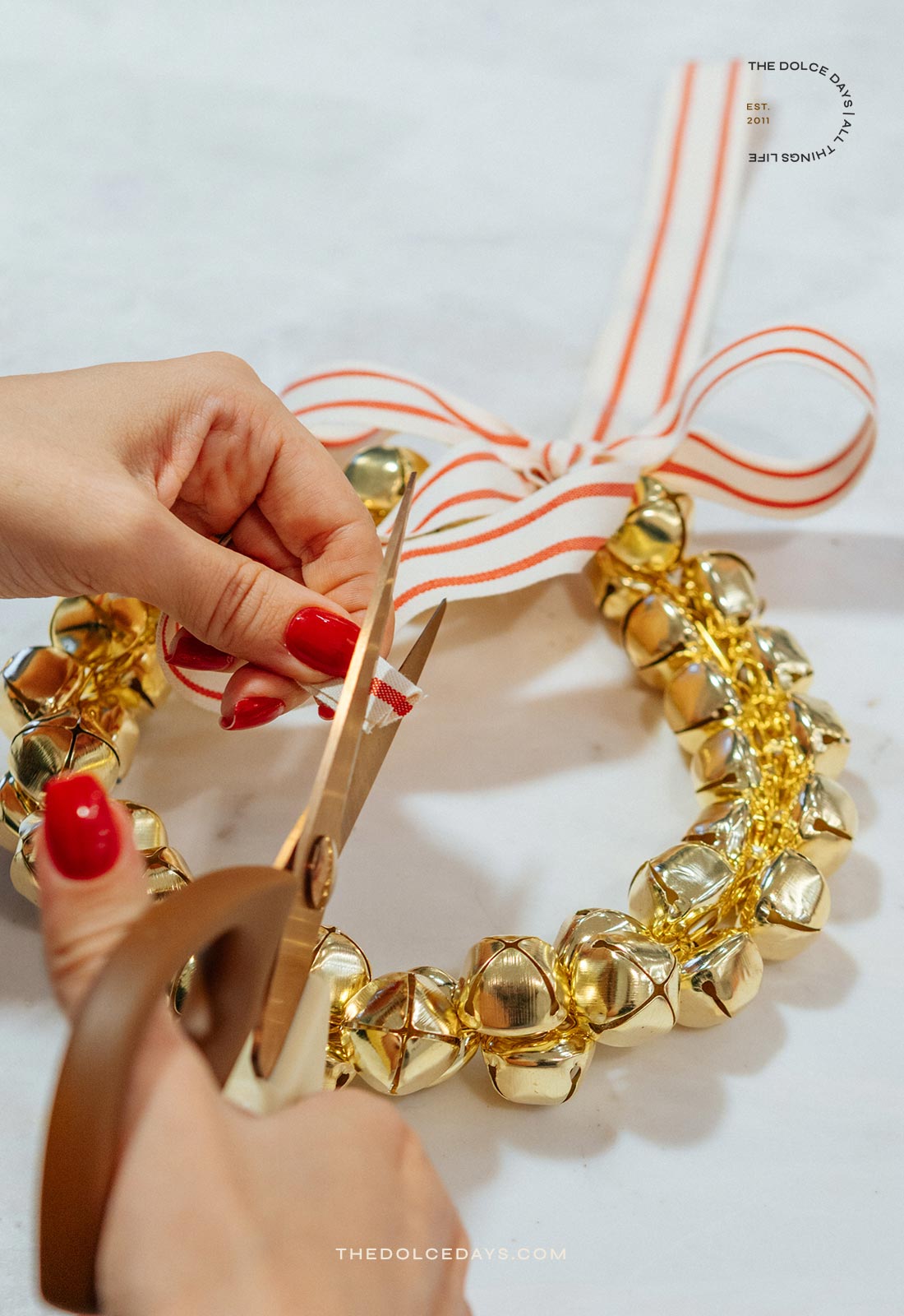 Cortando a pontinha do laço da guirlanda de guizos